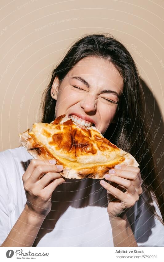 Woman Enjoying a Delicious Baked Cheburek woman baked cheburek eating savory pastry golden-brown crust filling veal tomatoes mozzarella cheese dor blue onions