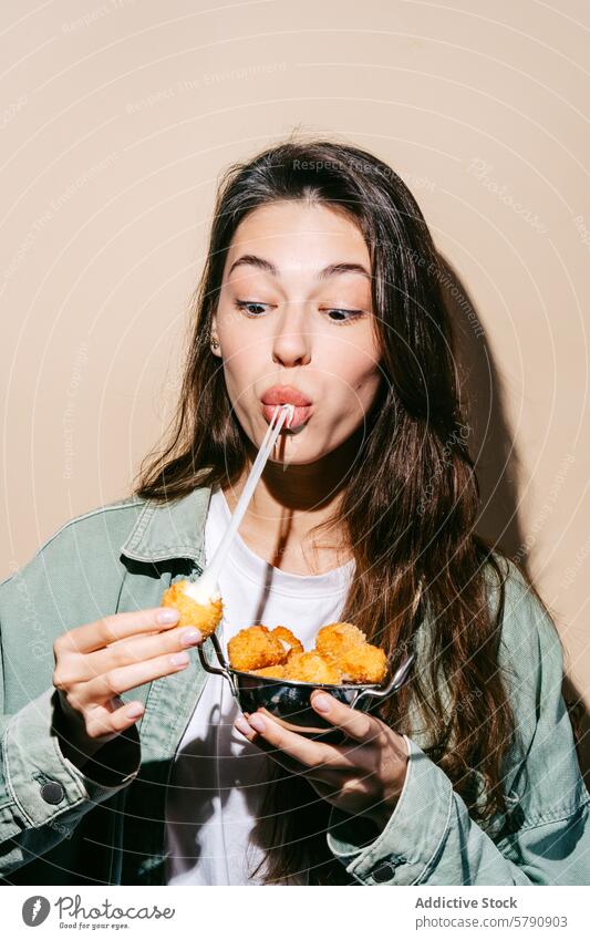 Woman enjoying cheese balls with a straw in mouth woman sip casual snack golden tasty appetizing informal eating holding bowl snack time bite modern young fresh