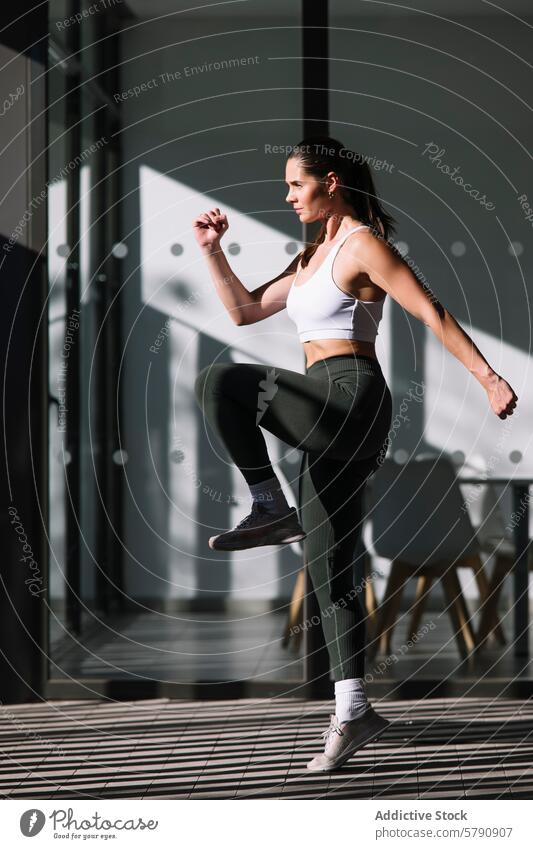 Athletic woman practicing indoors with modern backdrop athlete workout home fitness health lifestyle sportswear exercising interior living well-being practice