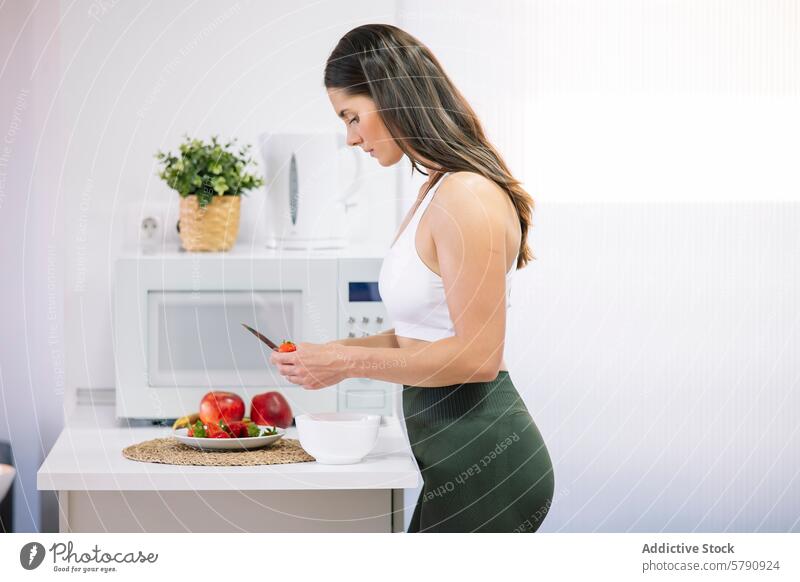 Athletic woman preparing healthy meal at home athletic preparation kitchen fitness activewear slicing vegetables nutrition lifestyle modern cooking wellbeing