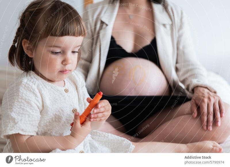 Child drawing on pregnant mothers belly, family moment child love sibling bond expression heart crayon maternity toddler woman pregnancy expecting care
