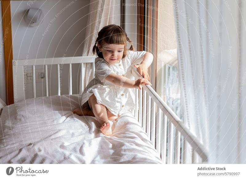 Toddler girl enjoys playtime on a sunlit bed toddler sunny window cozy bedroom cheerful child playing indoors home sunlight morning happy lifestyle nursery