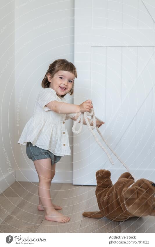Playful child with a toy in a bright room toddler girl play plush indoor joy happy cute innocent modern casual clothing smile preschool activity leisure playful