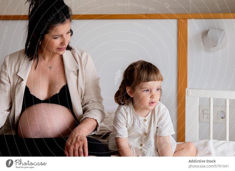Pregnant woman and child enjoying a quiet moment pregnancy mother daughter bedroom family maternity bonding peaceful serene togetherness love expectations