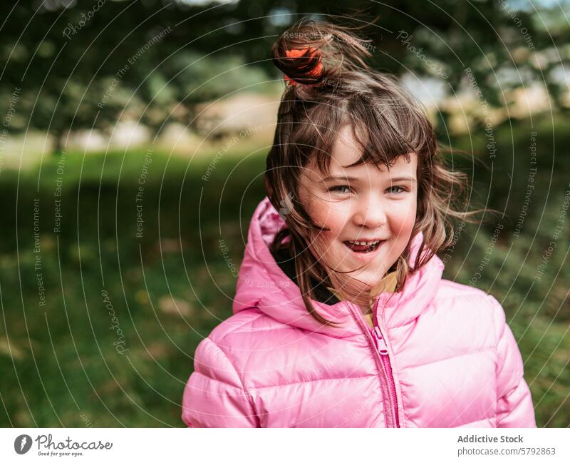 Smiling Girl in Pink Jacket Enjoying Family Time Outdoors girl smile family leisure outdoors portrait pink jacket hairstyle happiness child fun expression