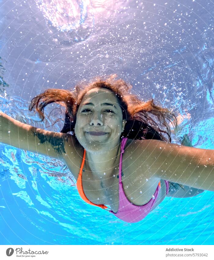 Underwater bliss of a young woman enjoying a swim underwater expression sunlight clear swimming female happy pool summer leisure refreshing portrait face