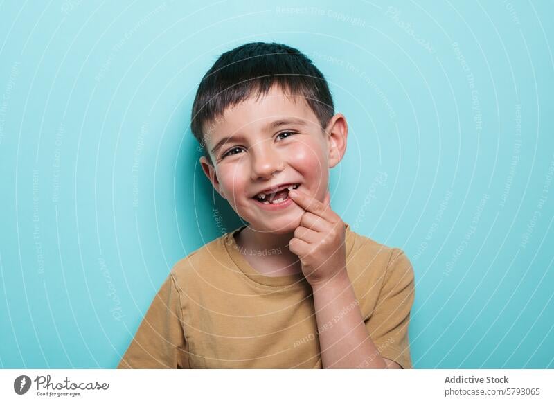 Cheerful boy showing his missing tooth child smile toothless portrait studio happy blue background cheerful joy youth kid innocence excitement childhood playful