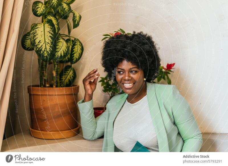 Professional woman enjoying a break in a coworking space african american smile modern potted plant sitting professional happy radiant indoors business