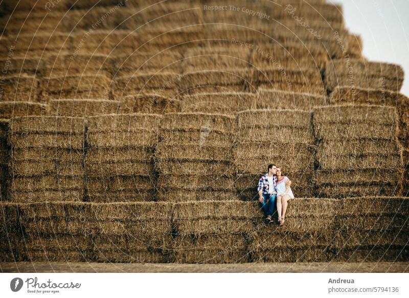 a guy with a girl on a summer walk in the field round haystack dry yellow dress shirt cage drawing pattern warehouse mountain sunset evening village farmer