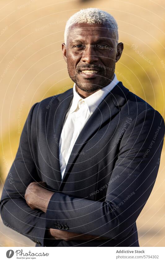 A dignified African American man with distinctive white hair confidently poses outdoors in a sharp suit, exuding professionalism confidence portrait