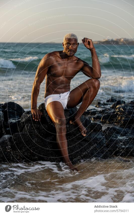 Beach Portrait of a Muscular African American Male Model beach model male muscular african american black confidence pose rocks sunset body athletic strength