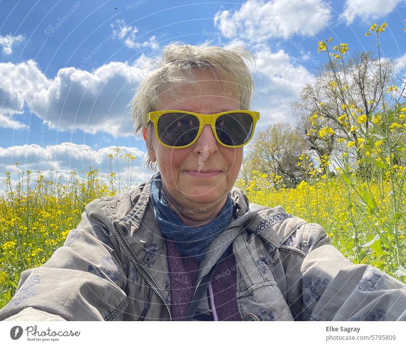 Blonde woman with yellow sunglasses in front of a rape field Woman Feminine Canola field Yellow sunglasses Close-up Sunglasses Adults pretty Human being Day