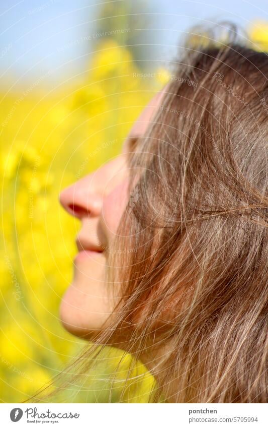 Face of a smiling woman in profile in a rape field Canola Canola field Agriculture Organic farming Yellow extension plants Agricultural crop Oilseed rape flower