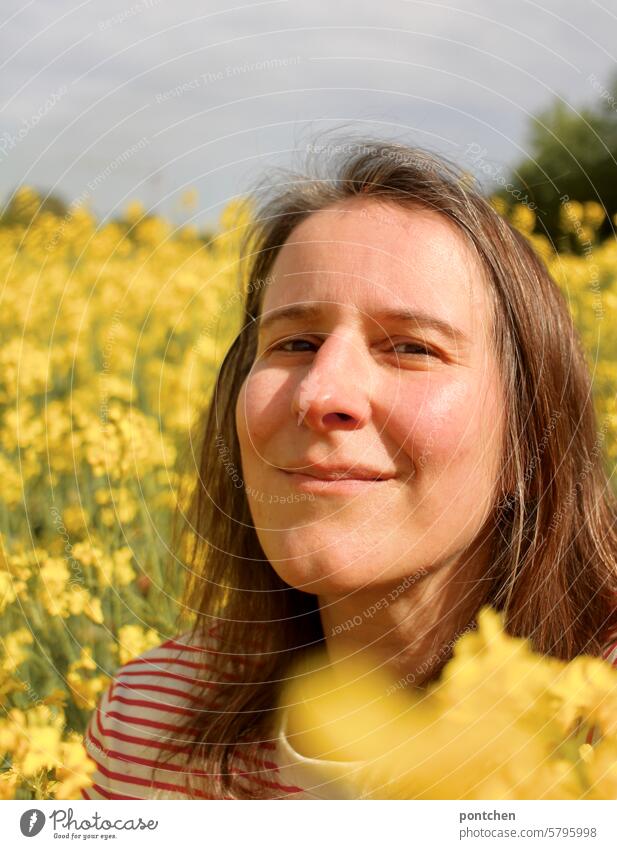 a smiling woman in the rape field Canola Canola field Agriculture Organic farming Yellow extension plants Agricultural crop Oilseed rape flower Spring Nature