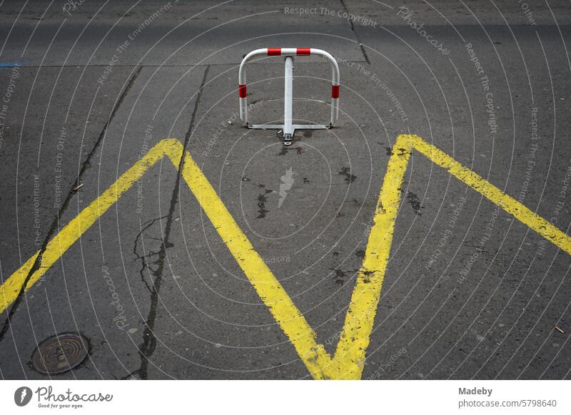 Folding parking barrier with bright yellow hatched markings on the asphalt in the old town of Prague in the Czech Republic Communism Socialism gentrified