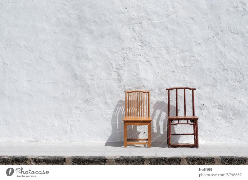 two empty old wooden chairs in front of a whitewashed wall Wooden chair White white wall Wall (building) Mediterranean Summer heat wave ardor Hot Dry aridity