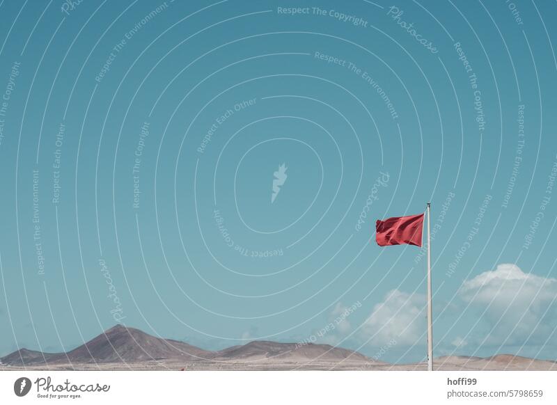 Red flag in the wind against a blue sky and mountainous panorama red flag Flag Warn Warning colour esteem exempt Minimalistic Exterior shot Safety Warning label