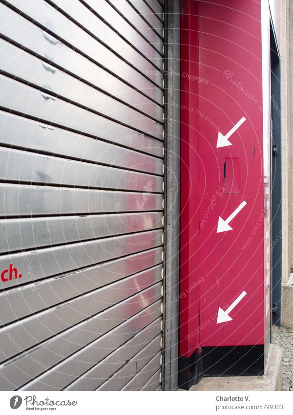 Drei Pfeile zeigen auf ein Metalltor 3 Pfeile Metalllamellen Eingang Eingangssituation Garagentor Rot Weiß Silber Hinweis urban klar einfach