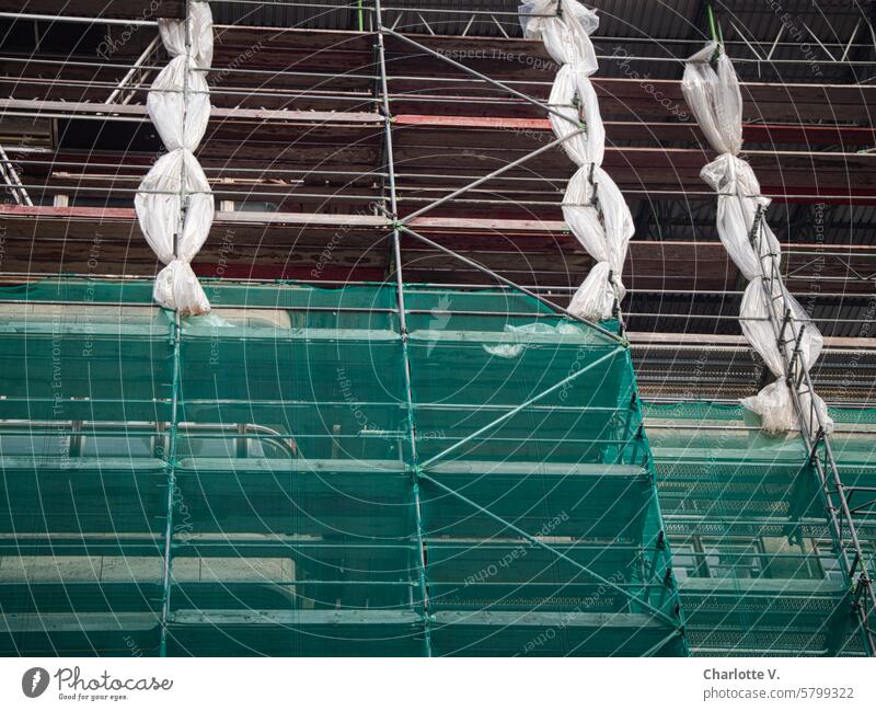 Baugerüst mit Zöpfen bauen Gebäude Fassade Stangen Planen Grün Rot Weiß Struktur Froschperspektive