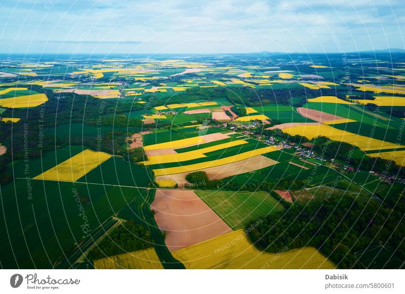 Aerial view of landscape with blooming rapeseed on agricultural fields crops rural farmland colors green yellow contrasting variety farming plantation nature