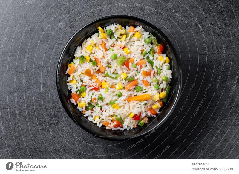 White rice with vegetables in a black bowl on wooden table carrot chickpea corn diet dish food green beans healthy isolated mix recipe stone white