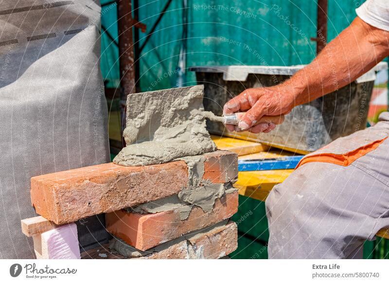 Worker is building wall of brick of building under construction Among Between Brick Bricklayer Bricklaying Brickwork Builder Building Site Civil Engineering