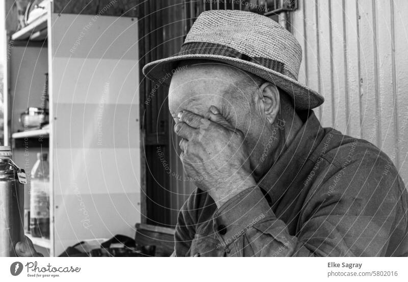 Thoughtful man covers his face middle-aged man Mid adult man Person wearing glasses portrait Exterior shot Masculine Black & white photo Hat Outsider