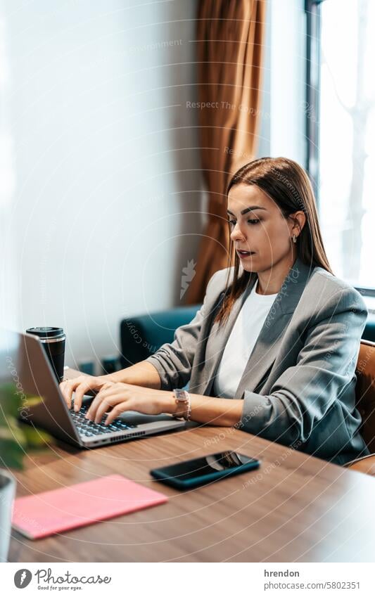 woman working in an office typing on the laptop businesswoman using indoor focused cyberspace entrepreneur technology professional connection manager success