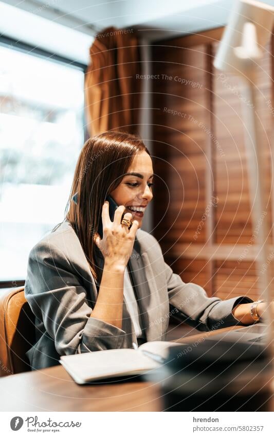 woman working in an office talking on the phone smartphone calling businesswoman mobile mobile phone laptop cellphone indoor entrepreneur professional manager