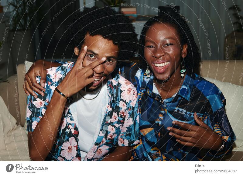 Cheerful Black couple in floral shirts taking selfie at home fun peace people Selfie posing black man Black woman boyfriend girlfriend happy positive smile