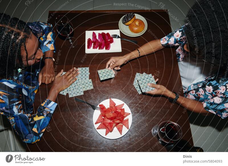 Black couple playing cards and eating fruits, view from the top game Snack tasty hands watermelon sweet wine alcohol Remainder relax fun leisure hangout group