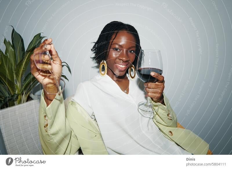 Young businesswoman drinking wine at office party alcohol positive smile flash excited drunk Party portrait Black woman celebrate Friday workplace dressed fun