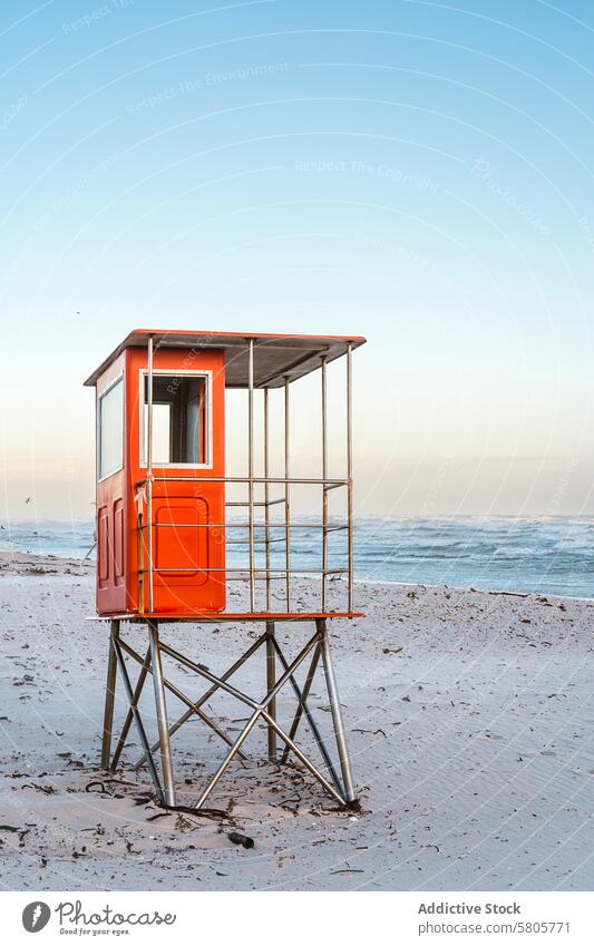 Lifeguard tower on a sandy beach at sunrise lifeguard tower ocean waves clear sky tranquil seascape coastline safety surveillance protection structure empty