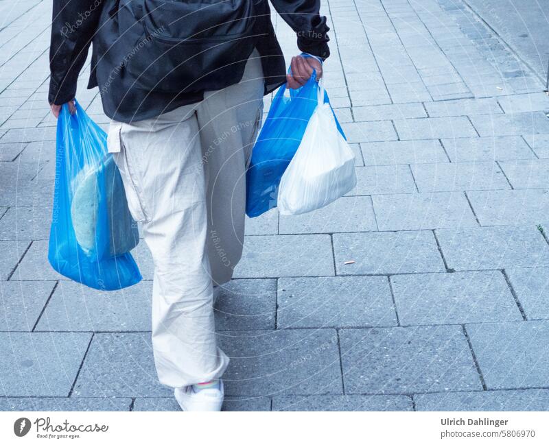Person from behind in white pants with blue and white shopping bag.dynamic while walking purchasing Haste Blue Single-minded Movement Street Consumption