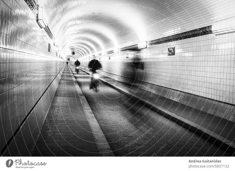 View inside the old Elbe tunnel in Hamburg St. Pauli, a cyclist approaches, long exposure, black and white, horizontal Old Elbe Tunnel Elbtunnel