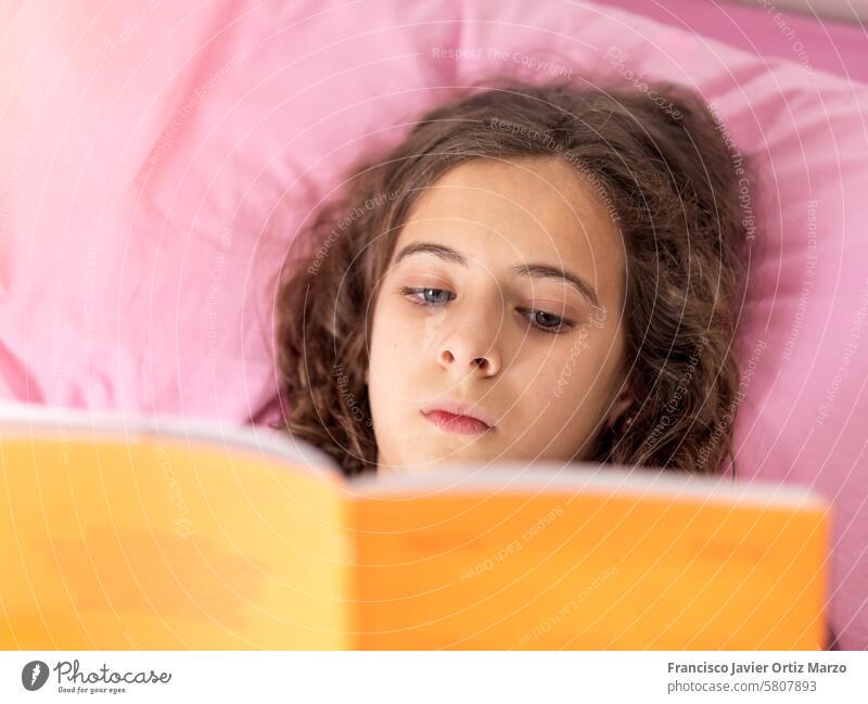 Young girl Reading Book in pink Bed young book reading bed comfort relax home leisure education literature youth bedroom cozy learning study sheets novel