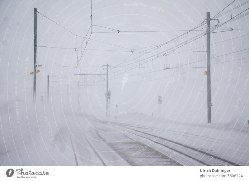 Overhead line, tracks and green signal in a snowstorm Winter Surm Snow Snowstorm Track White Weather Frost train failure Lateness cataclysm Ice