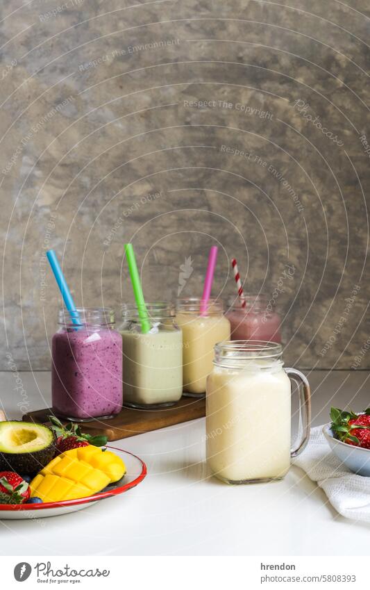 Colorful smoothie with avocado, pineapple, mango, strawberries, blueberries drink food fruit organic healthy breakfast juice glass diet cocktail beverage