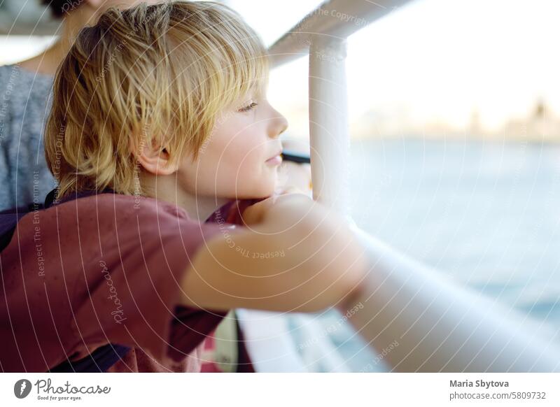 Cute blonde preteen tourist boy is traveling by boat or ferry on the sea. Family vacations on ocean or sea. Summer leisure for families with kids. child Turkey
