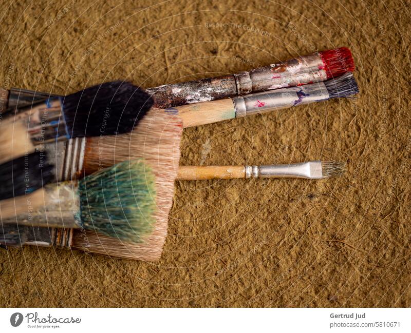 Old brushes on yellow fabric Patina Paintbrush Deserted Detail Close-up Structures and shapes Subdued colour Weathered Brown Painting (action, artwork) Painter