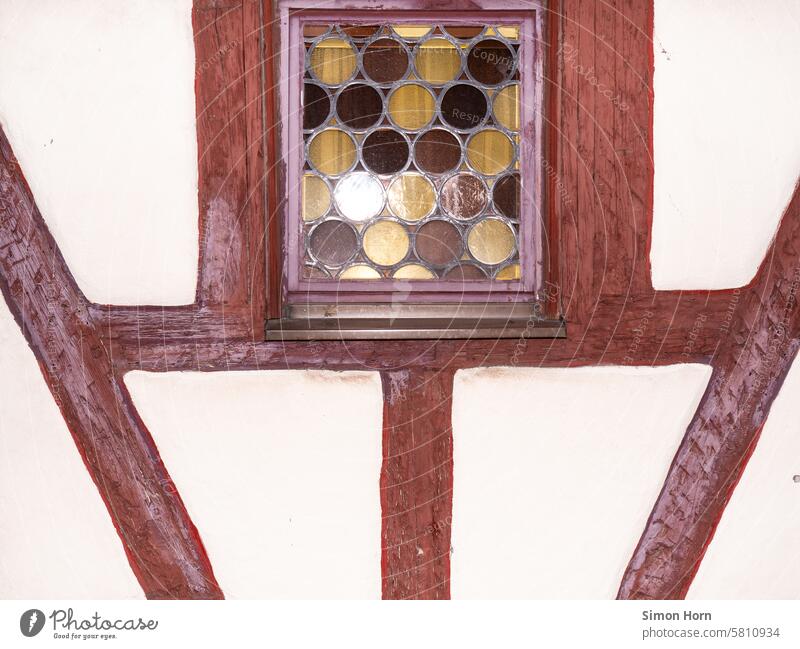 Detail of a half-timbered house, in the upper center of the picture is a window with a multicolored bull's-eye pane Half-timbered house Window Bullseye pane