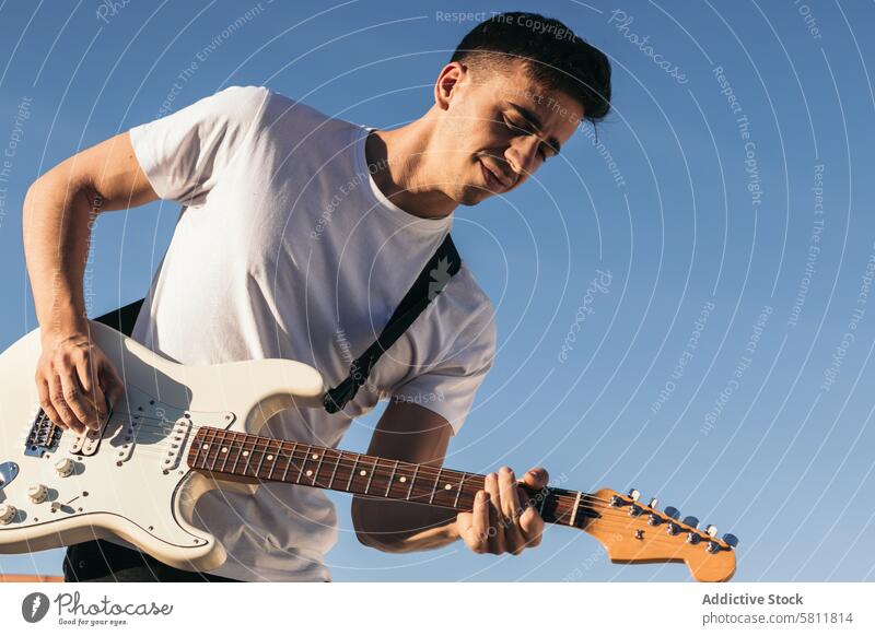 man playing electric guitar on a blue sky background musician guitarist musical rock instrument player person sound song concert young jazz blues rocker artist