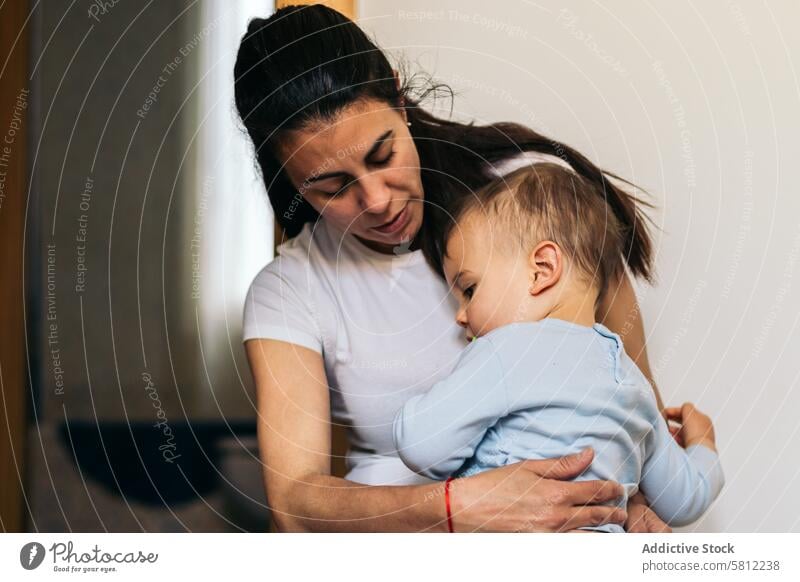 mother hugging her baby sitting at home love family child childhood kid woman happy mom care cute beautiful young parent little adorable holding portrait
