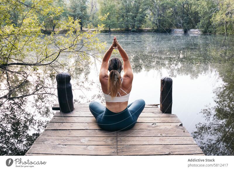 woman in sportswear doing yoga in nature near a lake meditation healthy relaxation body adult pose lifestyle balance exercise young person concentration zen