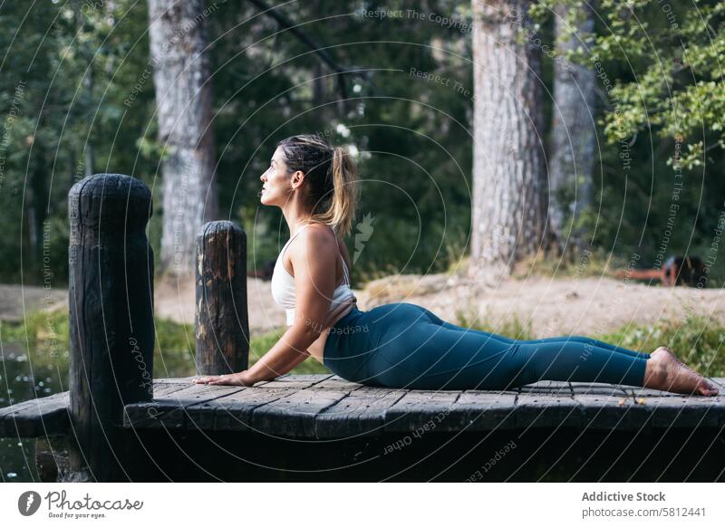 woman in sportswear doing yoga in nature near a lake healthy exercise lifestyle fitness body workout caucasian training pilates young wellness activity active