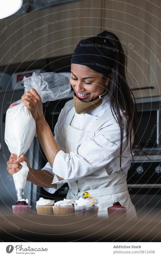 Female cook decorating cupcakes with whipped cream woman baker squeeze pastry bag bakehouse vegan dessert sweet treat smile baked tasty bakery food female yummy