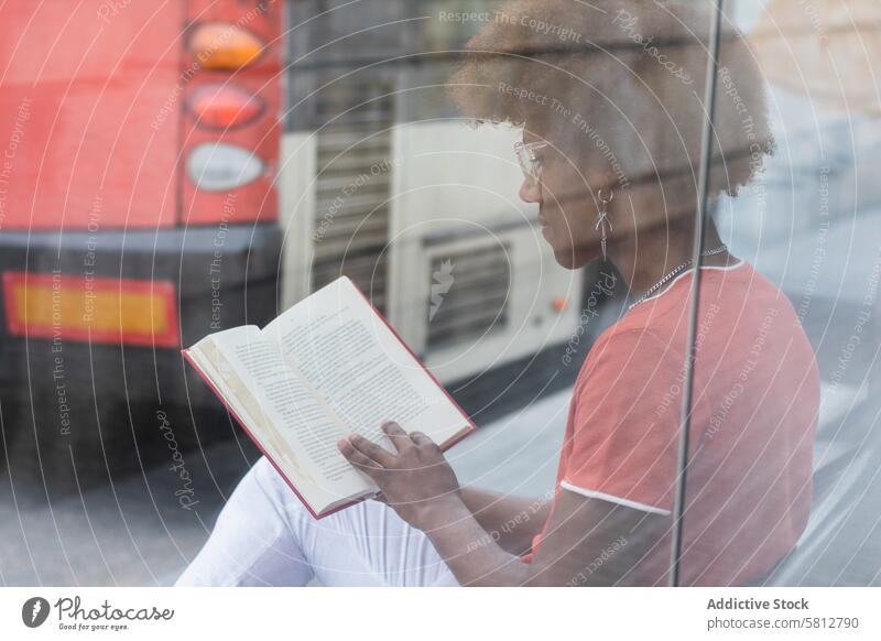 Stylish young black male reading book at bus stop man style concentrate literature bookworm calm relax interesting knowledge african american man black man