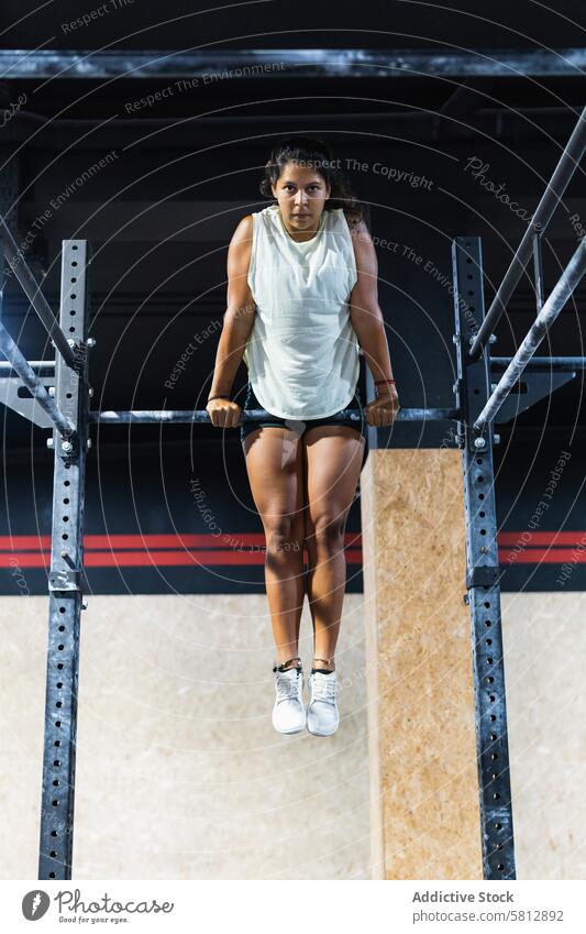 Hispanic sportswoman exercising on crossbar training gym exercise workout healthy lifestyle practice challenge sporty activewear sportswear wellness hobby