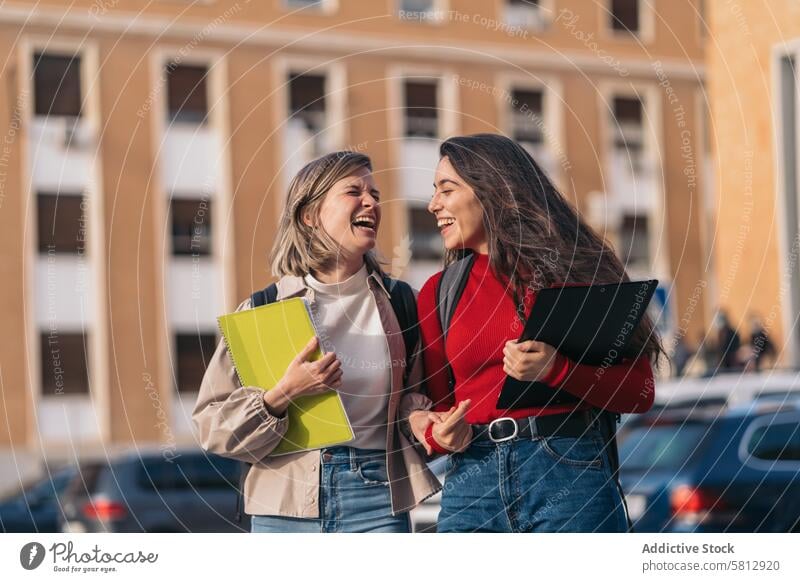 Two student girls laughing. young happy lifestyle fun people friendship teenager together woman two beautiful smiling cheerful female looking smile school youth