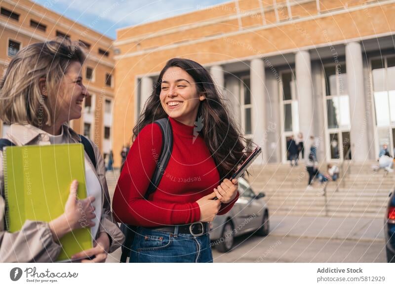 two student girls leaving class young laughing happy lifestyle fun people friendship teenager together woman beautiful smiling cheerful female looking smile